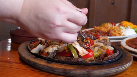 hand uses fork to fill taco with sizzling fajita meat, close up slow motion slider push 4k