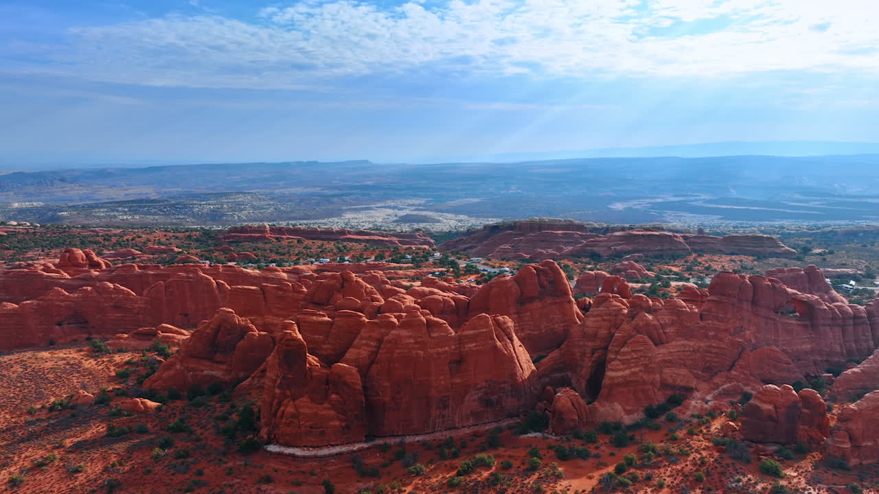 Vista panoramica sulla straordinaria bellezza dell'Arches National Park, Utah, USA. Avvicinamento alle creste di rocce rosse disposte in file. Una strada con diverse auto parcheggiate sullo sfondo