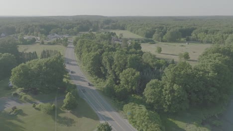 Falling-Aerial-Tilt-over-New-Hampshire-Road,-summer-and-Green-trees