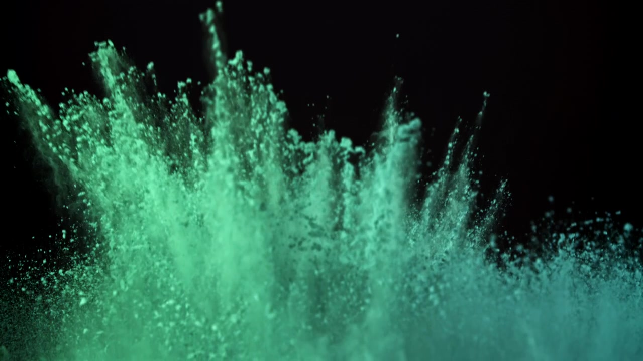 Slowmotion-eksplosion af grønt pudder mod en sort baggrund
