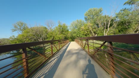 Paseo-En-Bicicleta-Por-El-Puente-Sobre-El-Camino-De-Grava-Del-Río