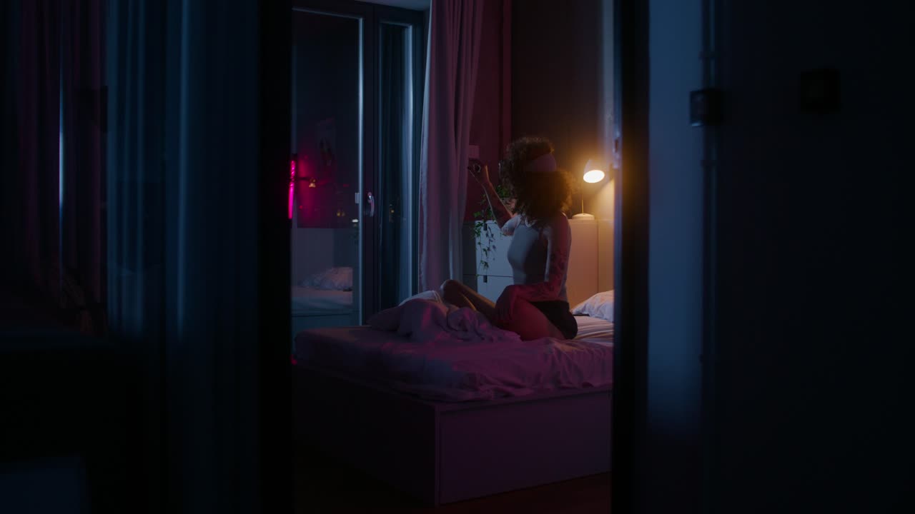 밤에 침실에서 vr 헤드을 착용한 여성
