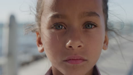 retrato de cerca joven niña de raza mixta buscando serio niño contemplativo en la soleada playa costera cámara lenta