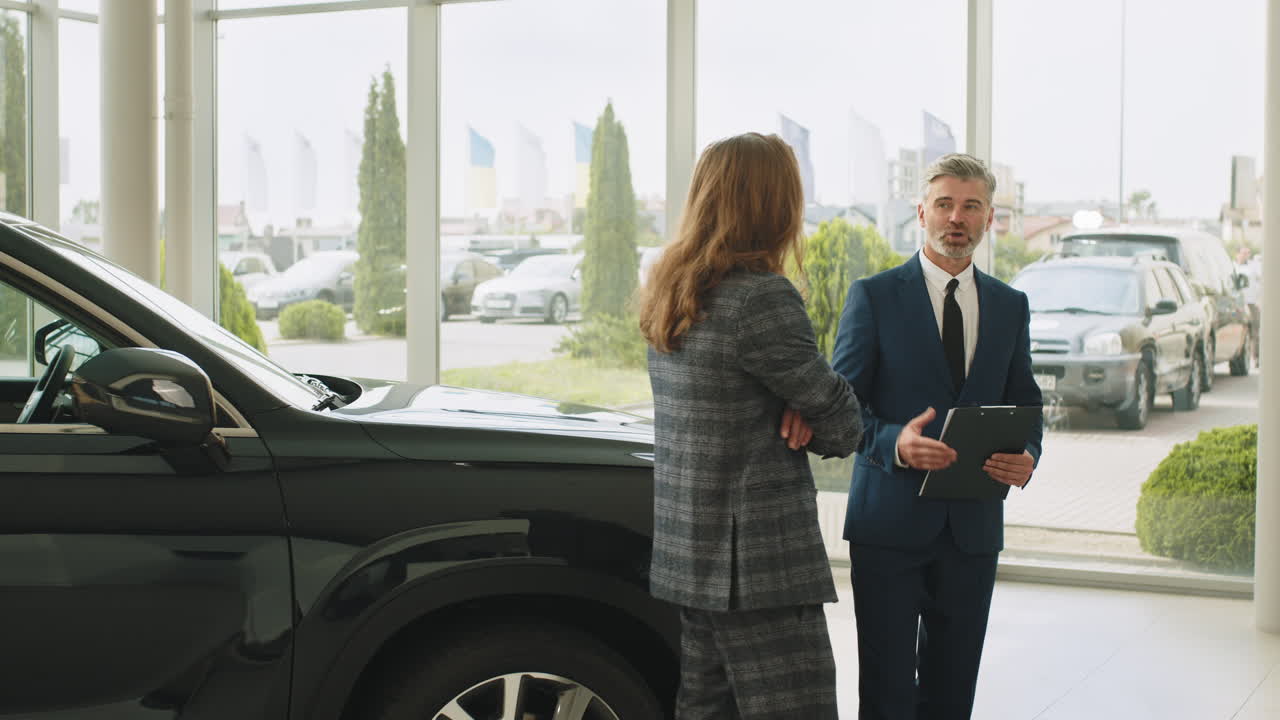 cliente discutiendo la compra de automóviles con el vendedor en el concesionario