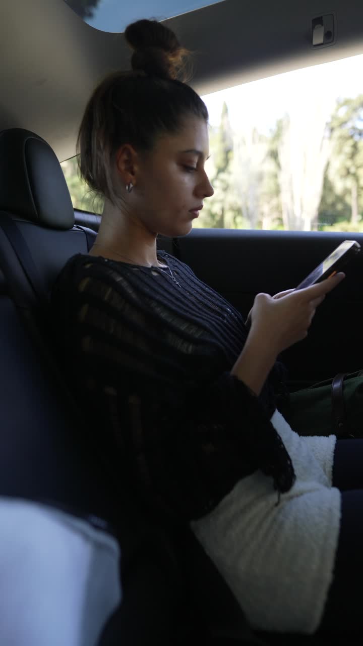 mujer usando un teléfono inteligente en un coche