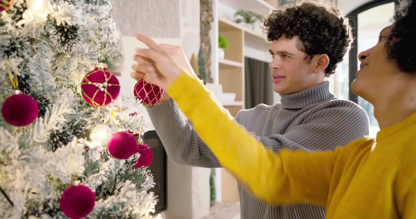 Coppia felice che decora un albero di Natale insieme a casa.