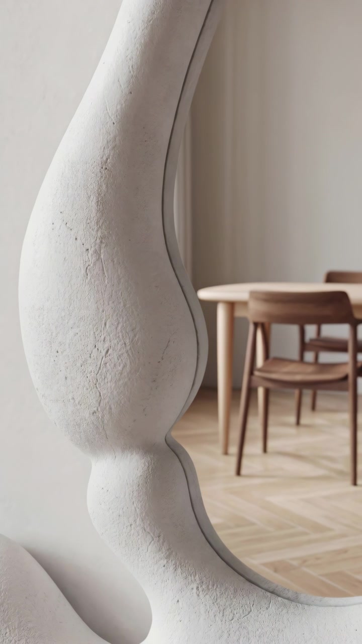 Balaústre escultural de gesso branco move-se lateralmente através de um interior moderno e neutro, revelando gradualmente uma mesa de jantar de madeira, cadeiras, piso em espinha de peixe, sombras suaves e uma decoração refinada com um toque delicado.