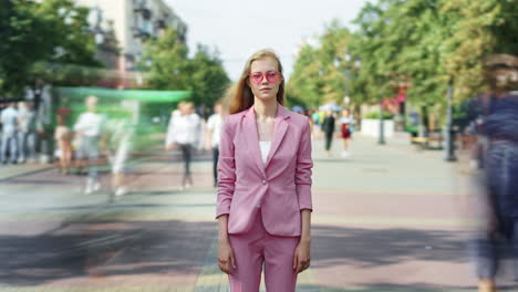 woman in pink suit on city street