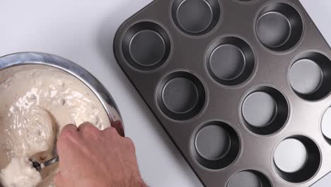 filling a muffin pan with a spoon