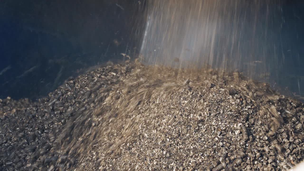 Pressed wooden briquettes coming out of the industrial equipment. Biomass fuel and environmental protection concept