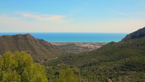 High-angle-shot-over-Benicassim-from-natural-park-from-Las-Palmas-in-Valencian-Community,-Spain-on-a-sunny-day