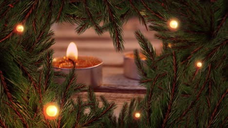 animation of christmas decoration with fairy lights and fir tree branches over candles