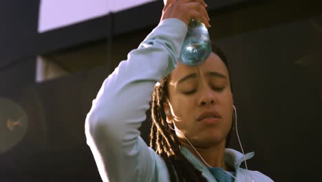 Front-view-of-young-African-American-woman-resting-after-exercising-in-the-city-4k