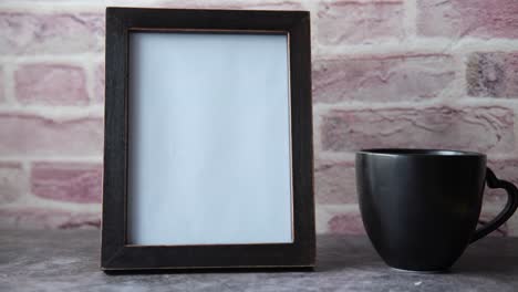 blank photo frame and mug on a table