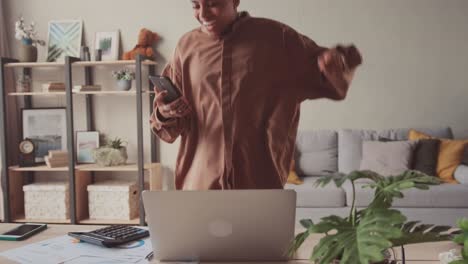 young african woman celebrate victory triumph look at smartphone