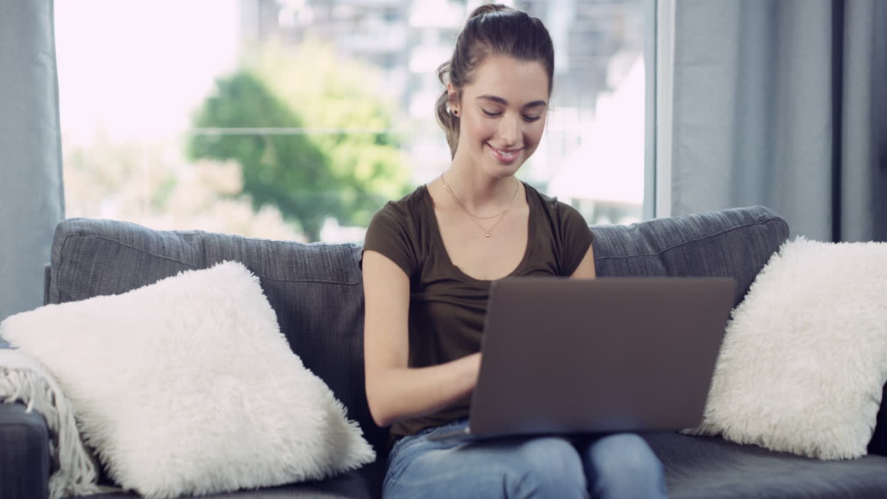 una mujer joven atractiva usando una computadora portátil en casa