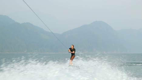 front view of caucasian young man doing tricks on wakeboard in the city river 4k