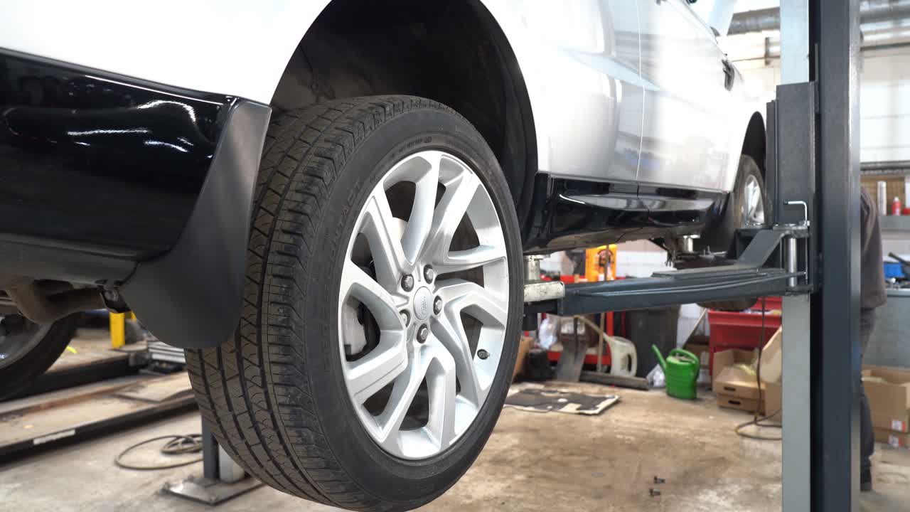 A technician removes a car's wheels in the workshop