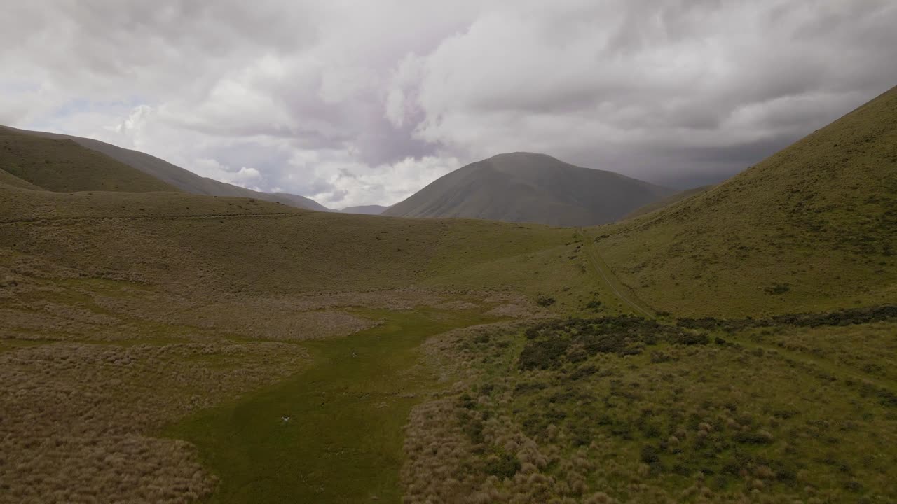 cielo dramático sobre matorrales de matas y colinas escarpadas en nueva zelanda