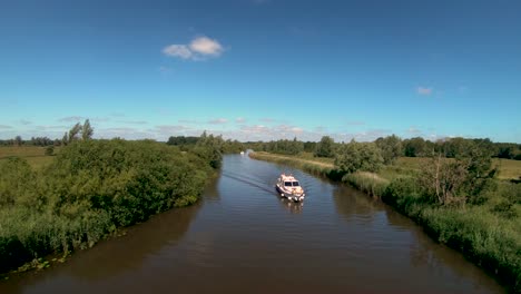 Aerial-Drone-Footage-of-a-boat-along-the-River-Waveney,-Norfolk