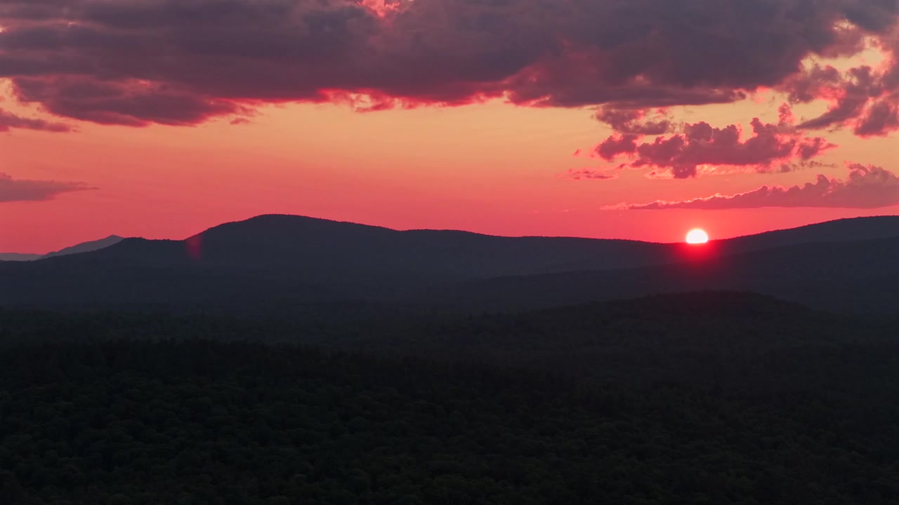 Adirondack-bjerglag Schroon Lake levende solnedgang gylden time rød ildsol ved horisonten skyer New York State luftdrone høje tinder i lag Mount Severance Pharaoh Lake Wilderness cirkel højre