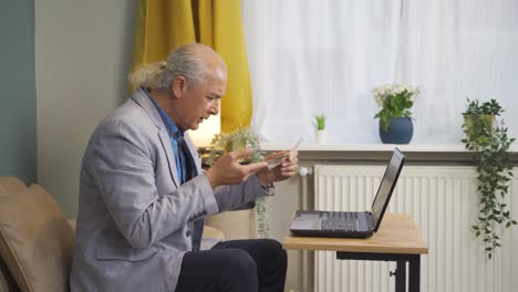 old man looking at high electricity bill turns off the lights.