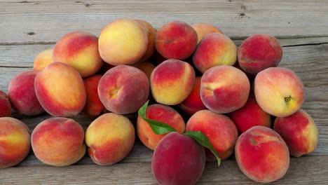 pile of peaches. ripe peaches fruit on a brown wooden background.