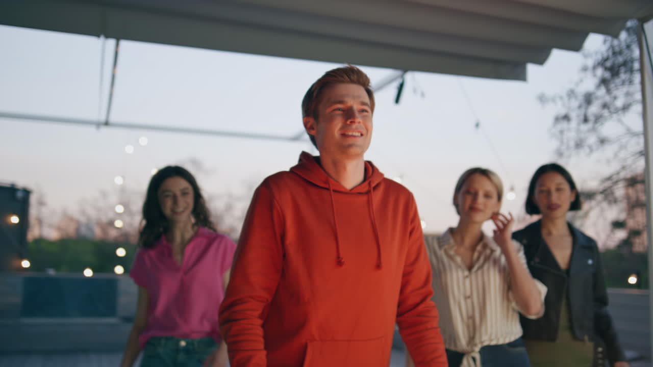 Happy man ordering drinks at outdoor bar. Diverse people resting cafe terrace