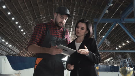 businesswoman and worker discussing plans in a warehouse