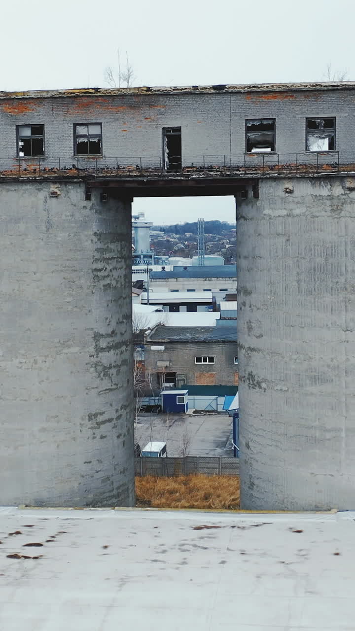 Old abandoned factory with concrete pipes and broken windows. Chemical plant storage. Aerial view. Vertical video