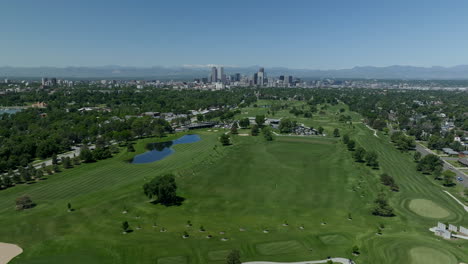 downtown denver city park golf course cityscape rocky mountain landscape 14ers mount evans aerial drone cinematic parallax foothills colorado spring summer green lush upward pan forward movement