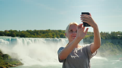 turista se toma selfie junto a las cataratas del niágara