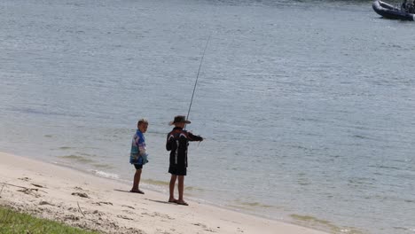 two people fishing by the water