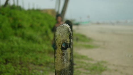 A-beachside-view-of-a-young-Asian-woman-in-a-blue-dress-walking-towards-the-camera