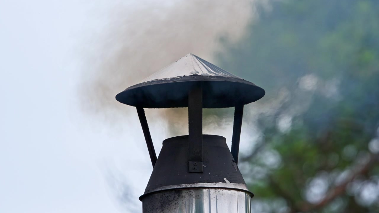 Primo piano di un camino che emette fumo nel cielo