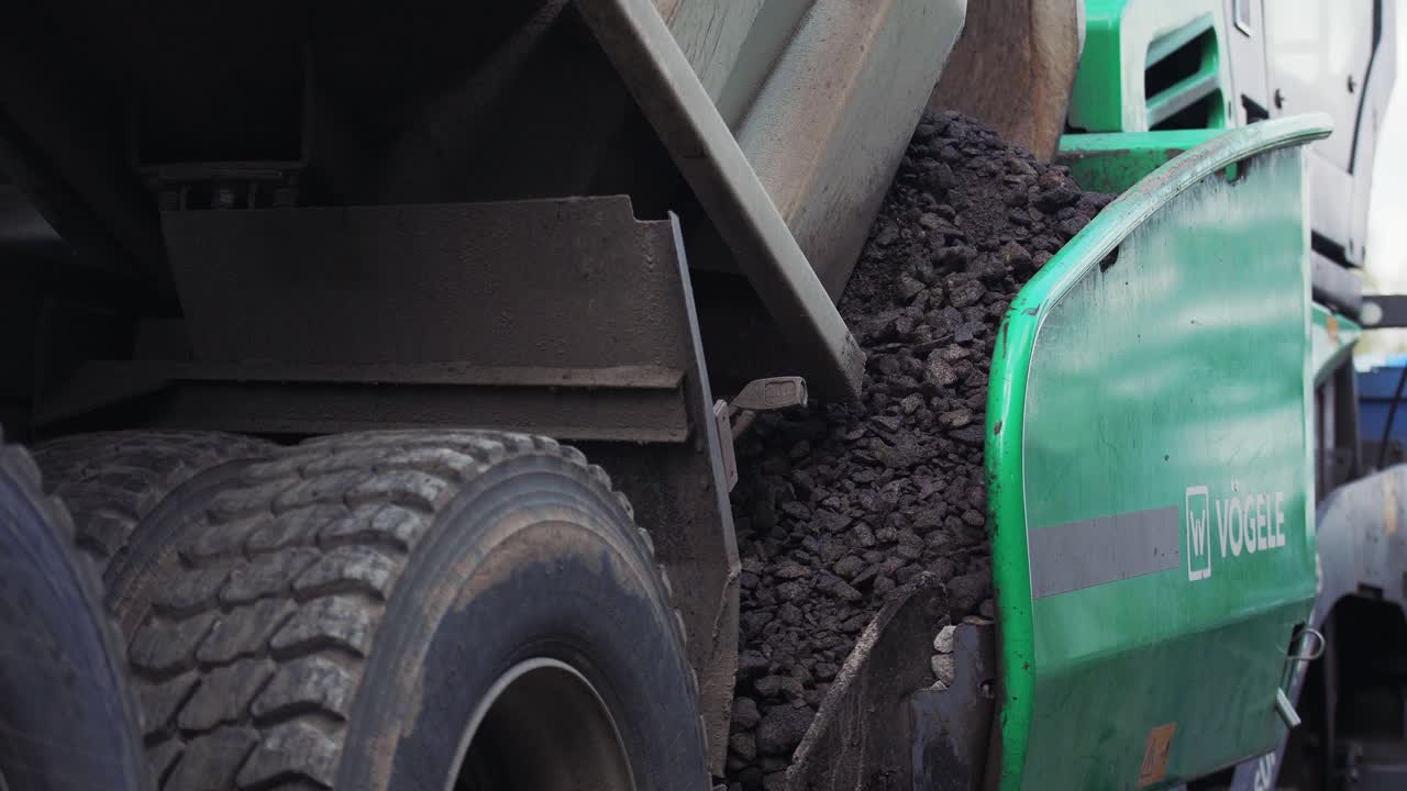 VINNYTSIA, UKRAINE - SEPTEMBER 10, 2018: the truck pours asphalt into the asphalt paver