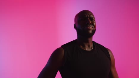 Close-Up-Studio-Portrait-Of-Male-Basketball-Player-Dribbling-And-Bouncing-Ball-Against-Pink-Lit-Background-3