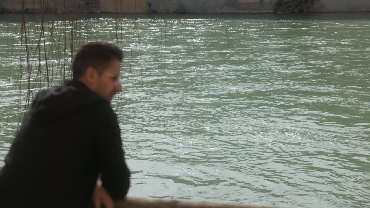 흐르는 강물 위에 있는 나무 다리 위의 관광객의 초상화