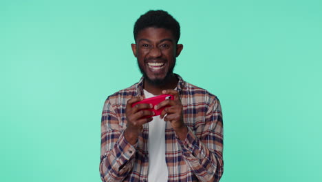 worried funny addicted african american man playing drive racing video games on mobile phone