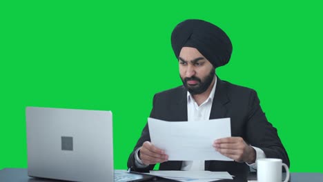 angry sikh indian businessman working on laptop green screen