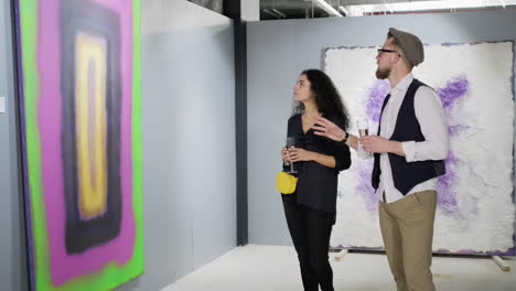 pareja viendo arte abstracto en una galería de arte