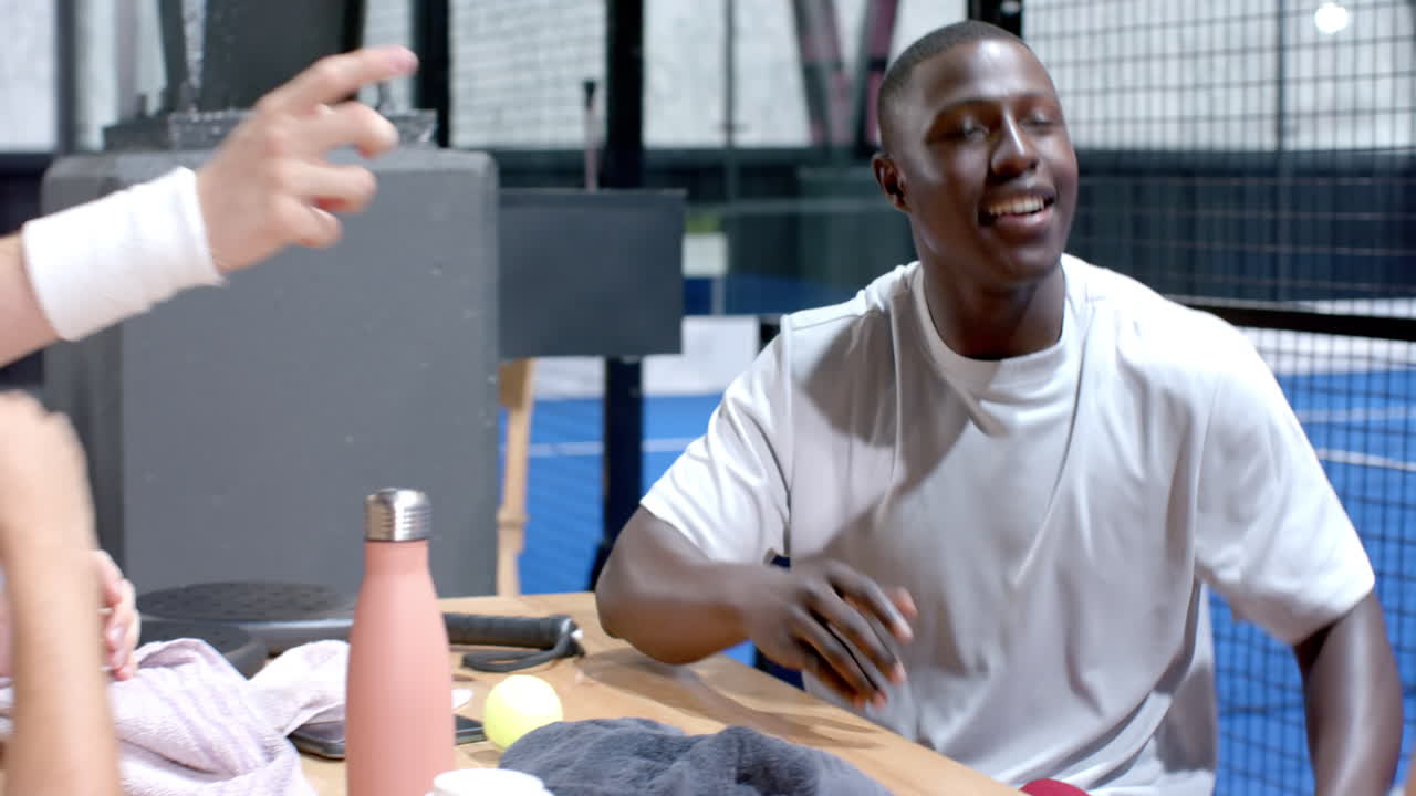 Focused athlete playing padel tennis in modern on indoor court, preparing to serve