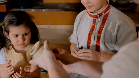 potter showing how to work with ceramic in pottery studio