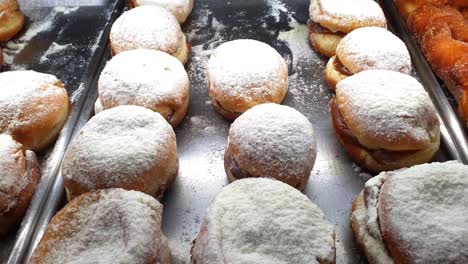 brazilian berliner with custard filling being displayed at a brazilian bakery showcase.