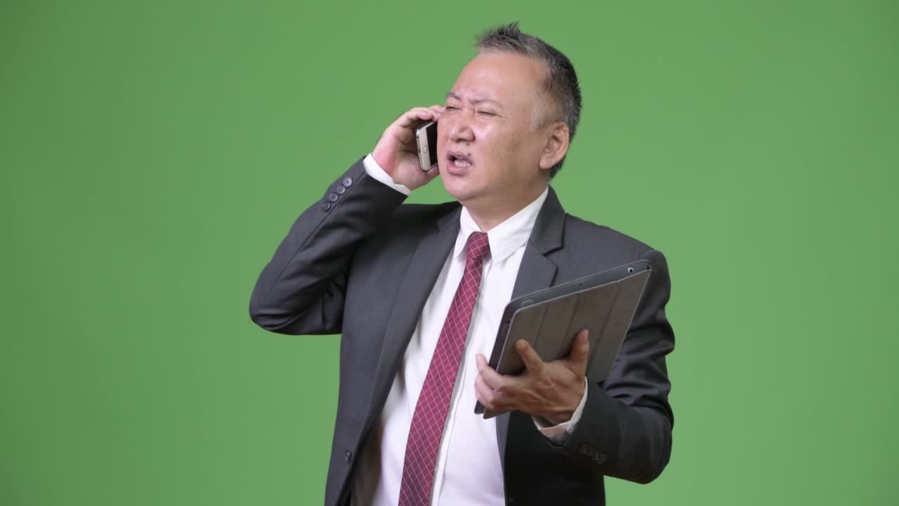 디지털 태블릿과 드폰으로 일하는 성숙한 일본 사업가