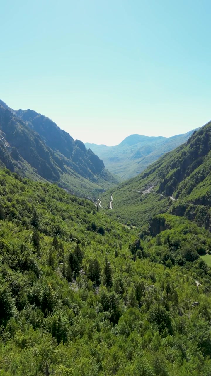 Filmato verticale con drone che si affaccia sulla lussureggiante valle di Theth nell'Albania settentrionale. Circondato dalle cime spettacolari delle Alpi Albanesi, questo paesaggio panoramico mostra uno dei luoghi più mozzafiato del paese