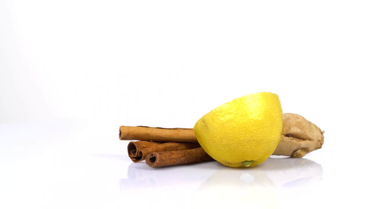 Endless Loop Of a Fresh Cinnamon Sticks, Lemon And Ginger Rotating On a White Background. Side View.