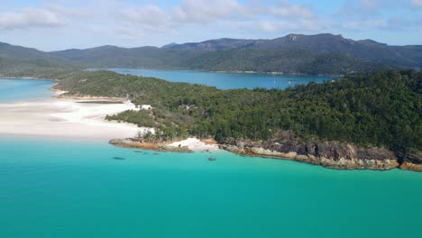 turquoise blue waters and swirling white sand with forested lookout