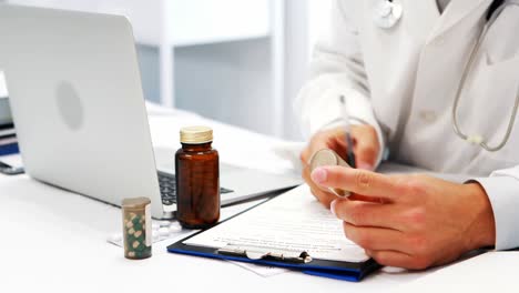 mid-section of male doctor checking medicine