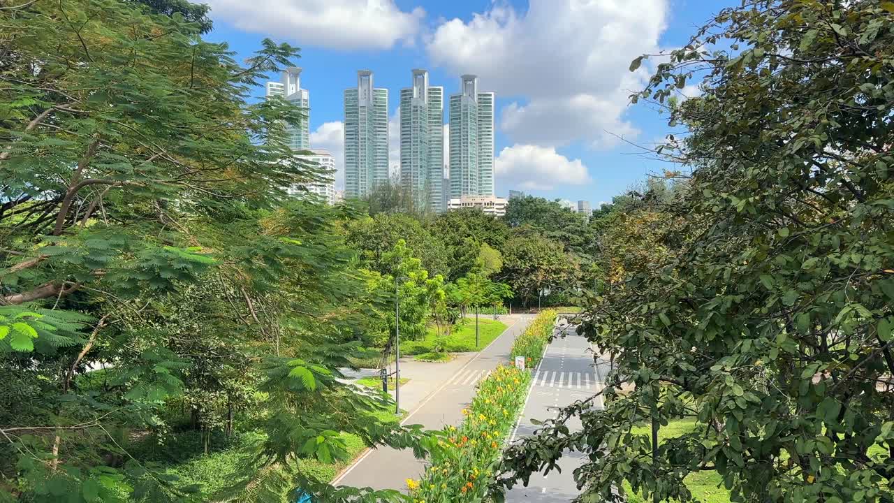 Bangkok Skyscrapers Skyline View from Benchakitti Park – City Buildings Behind Lake and Green Nature, Central Bangkok Thailand, Southeast Asia Urban Landscape Video